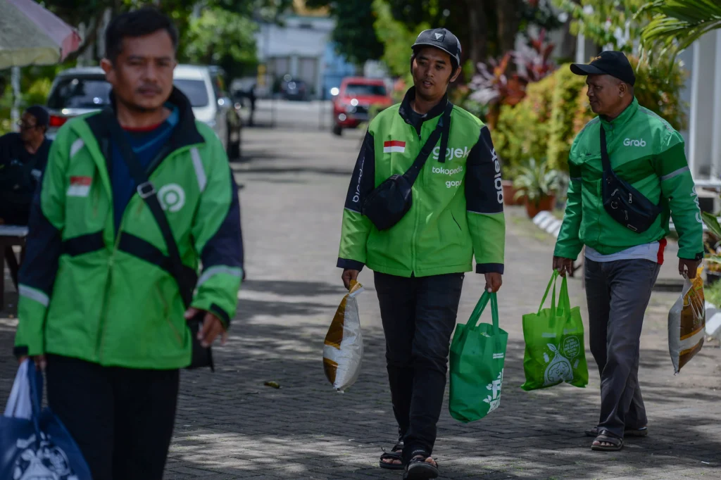 Pengemudi ojek online membawa paket sembako yang mereka terima di Kota Serang, Banten, Jumat (28/11/2025). Pengemudi ojek online membawa paket sembako yang mereka terima di Kota Serang, Banten, Jumat (28/11/2025).