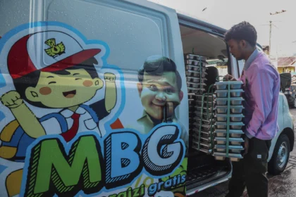 Petugas menyusun ompreng berisi makanan bergizi gratis ke dalam mobil sebelum didistribusikan kepada penerima manfaat di dapur Satuan Pelayanan Pemenuhan Gizi (SPPG) Polres Ternate di Ternate, Maluku Utara