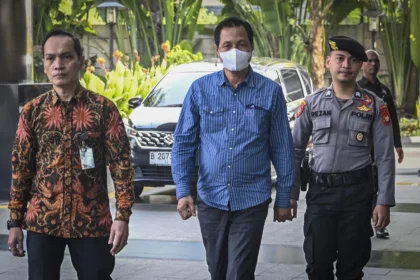Bupati Muara Enim Edison (tengah) dikawal petugas setibanya di Gedung Merah Putih KPK, Jakarta, Selasa (9/6/2026).