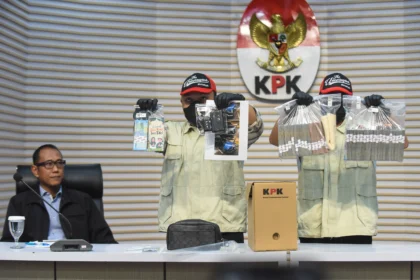 Petugas KPK menunjukkan barang bukti uang tunai disaksikan Plt. Direktur Penyidikan KPK Achmad Taufik Husein (kiri) saat konferensi pers gelar perkara operasi tangkap tangan (OTT) kasus dugaan suap audit laporan keuangan di Kabupaten Muara Enim oleh BPK, di Gedung Merah Putih KPK, Jakarta, Kamis (11/6/2026).