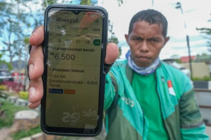 Seorang pengemudi ojek daring (ojol) menunjukkan riwayat pendapatannya di Kendari, Sulawesi Tenggara, Senin (29/6/2026).
